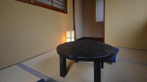 A tatami mat room with a low table and a traditional Japanese-style lamp. - Kyoto House (Kyoto)
