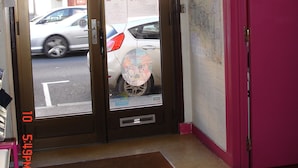 A hotel entrance with a closed pink door, a brown mat, and a sign reading "COMPLET" on the door. - Hotel La Marmotte (Niort)