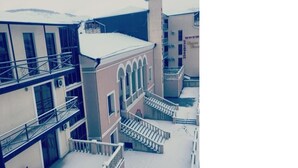 A multi-story hotel with a central courtyard, balconies, and a snow-covered ground. - Grand Palace (Akhaltsikhe)