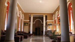 A spacious lobby with high ceilings, large columns, and a reception desk. - Grand Palace (Akhaltsikhe)