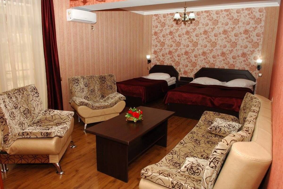 A hotel room with two beds, a sofa, a chair, and a coffee table.