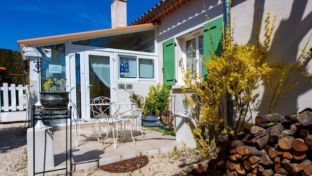 Une maison avec un patio, un espace salon extérieur et une pile de bois de chauffage.