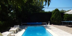 Una piscina al aire libre, sombrillas, tumbonas