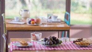 A breakfast table with a checkered tablecloth, a plate of figs, a muffin, and a glass of milk. - Tenuta Margherita (Nardò)