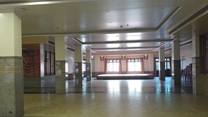 Un hall amplio con techos altos, ventanas grandes y un área de estar central.