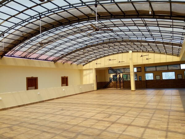 Un vaste espace intérieur doté d’un plafond haut et incurvé ainsi que d’un plancher en bois.