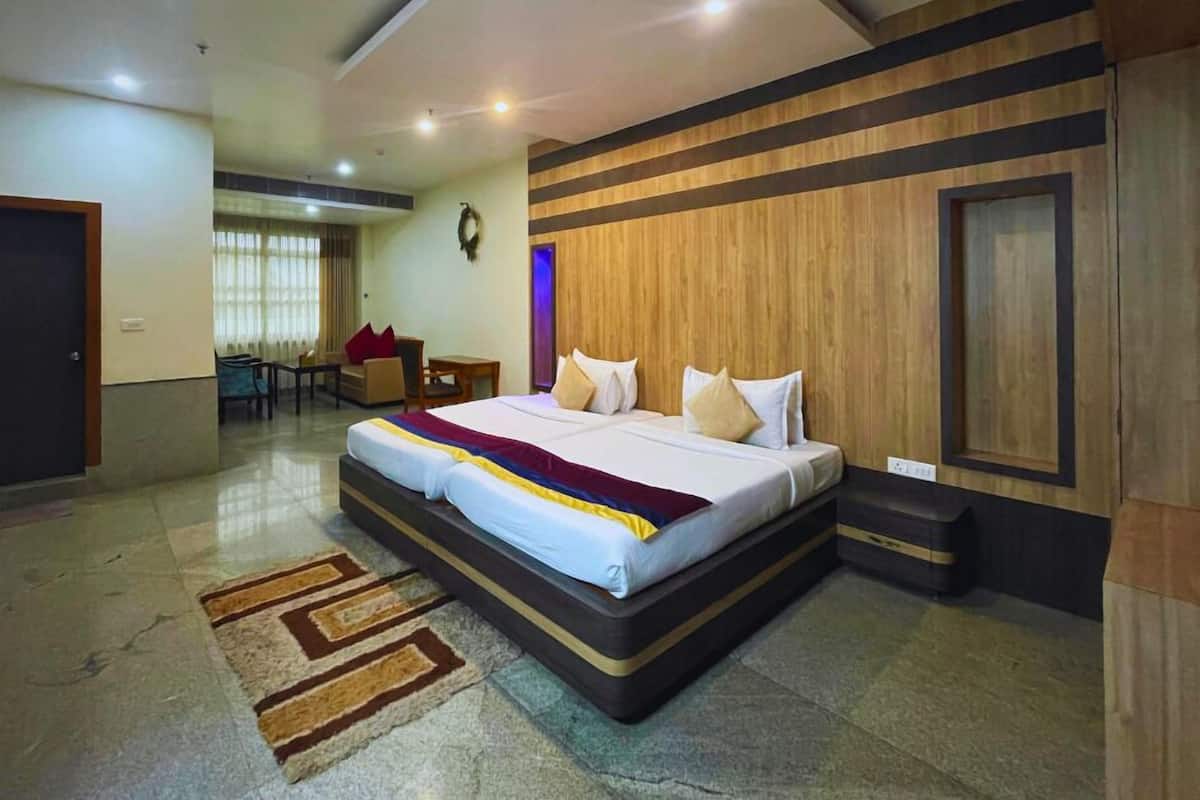 A hotel room with a large bed, a desk, and a chair.