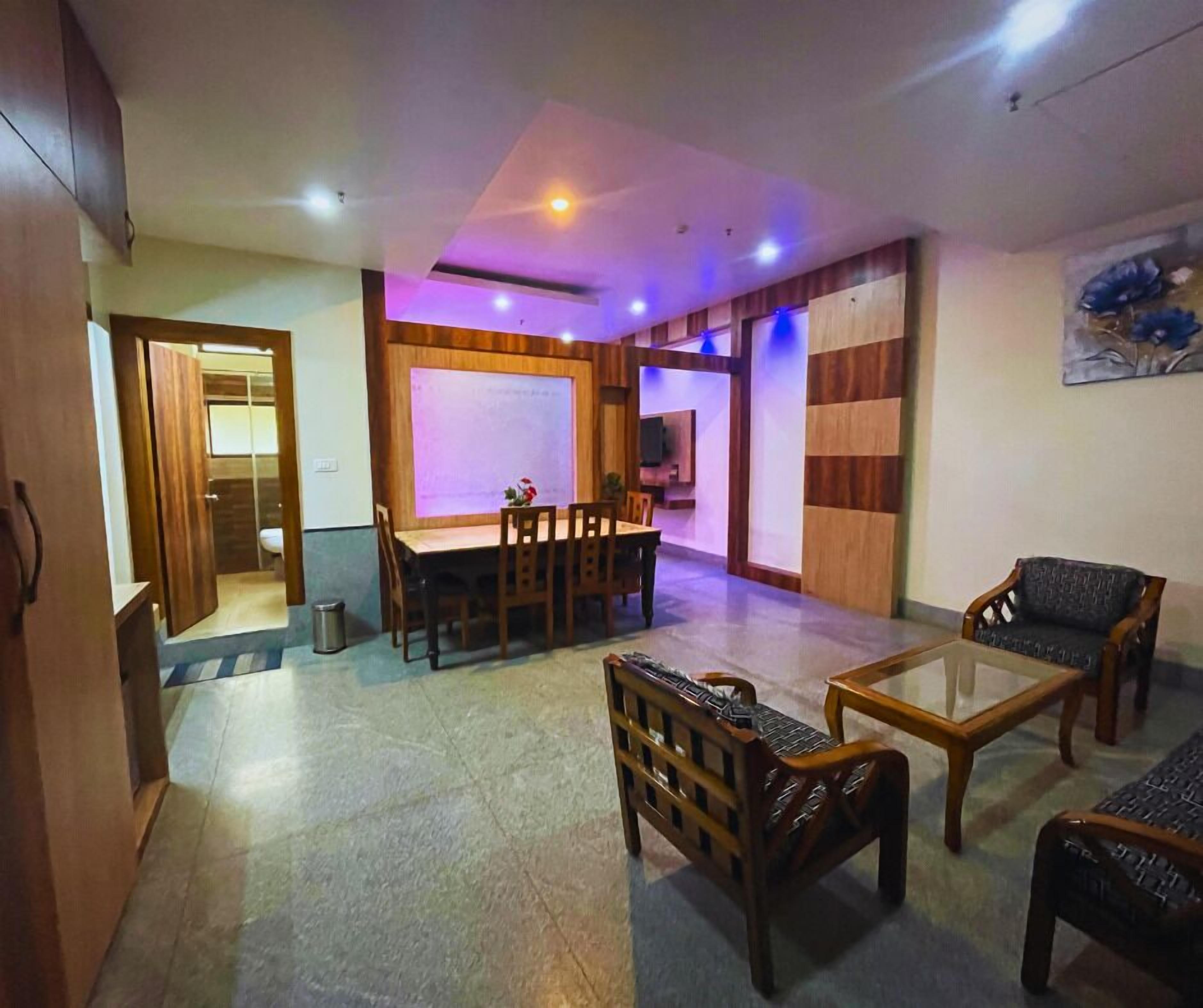 Un espacio habitable amplio con una mesa de comedor, sillas de madera y un sofá.
