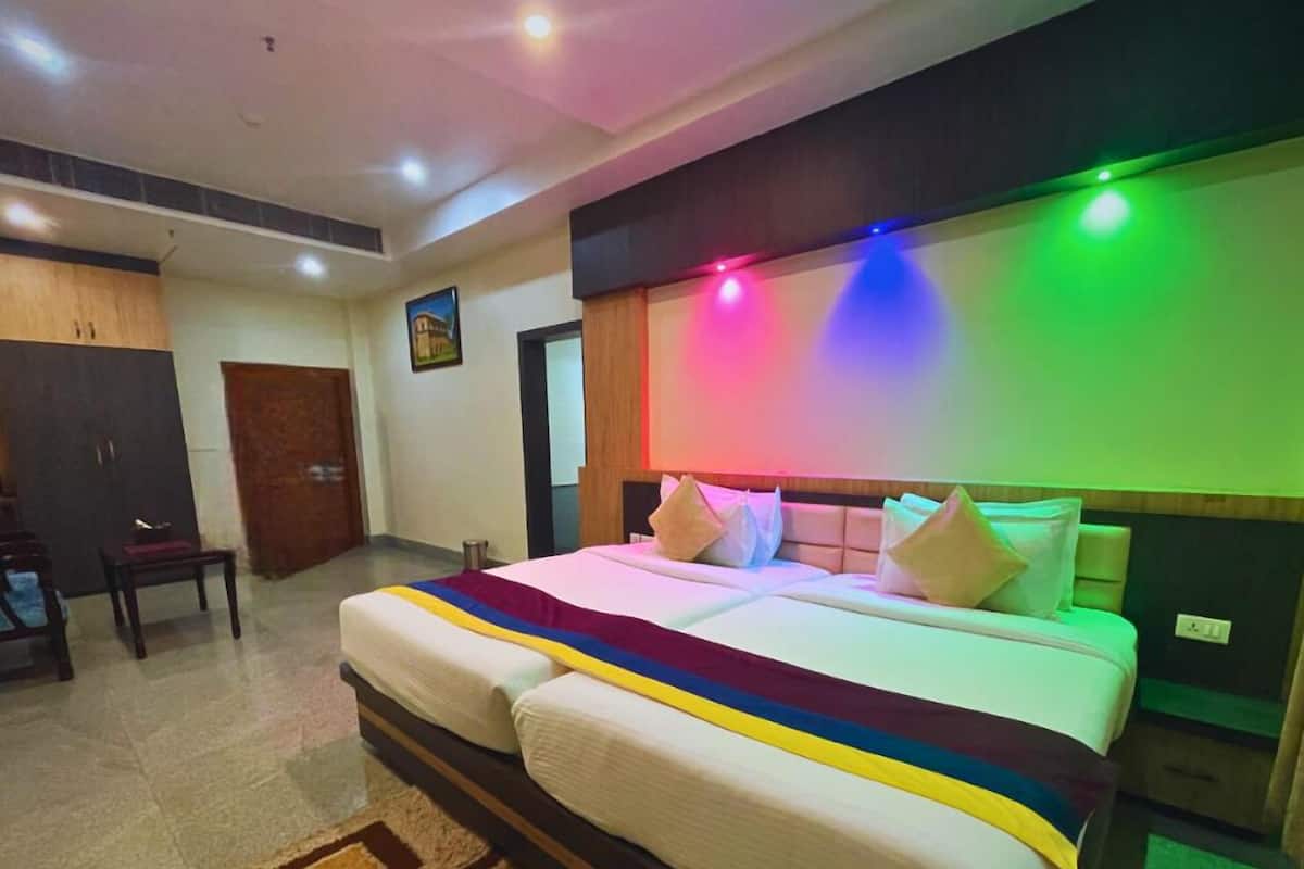 A hotel room with a bed, a desk, and a wardrobe.