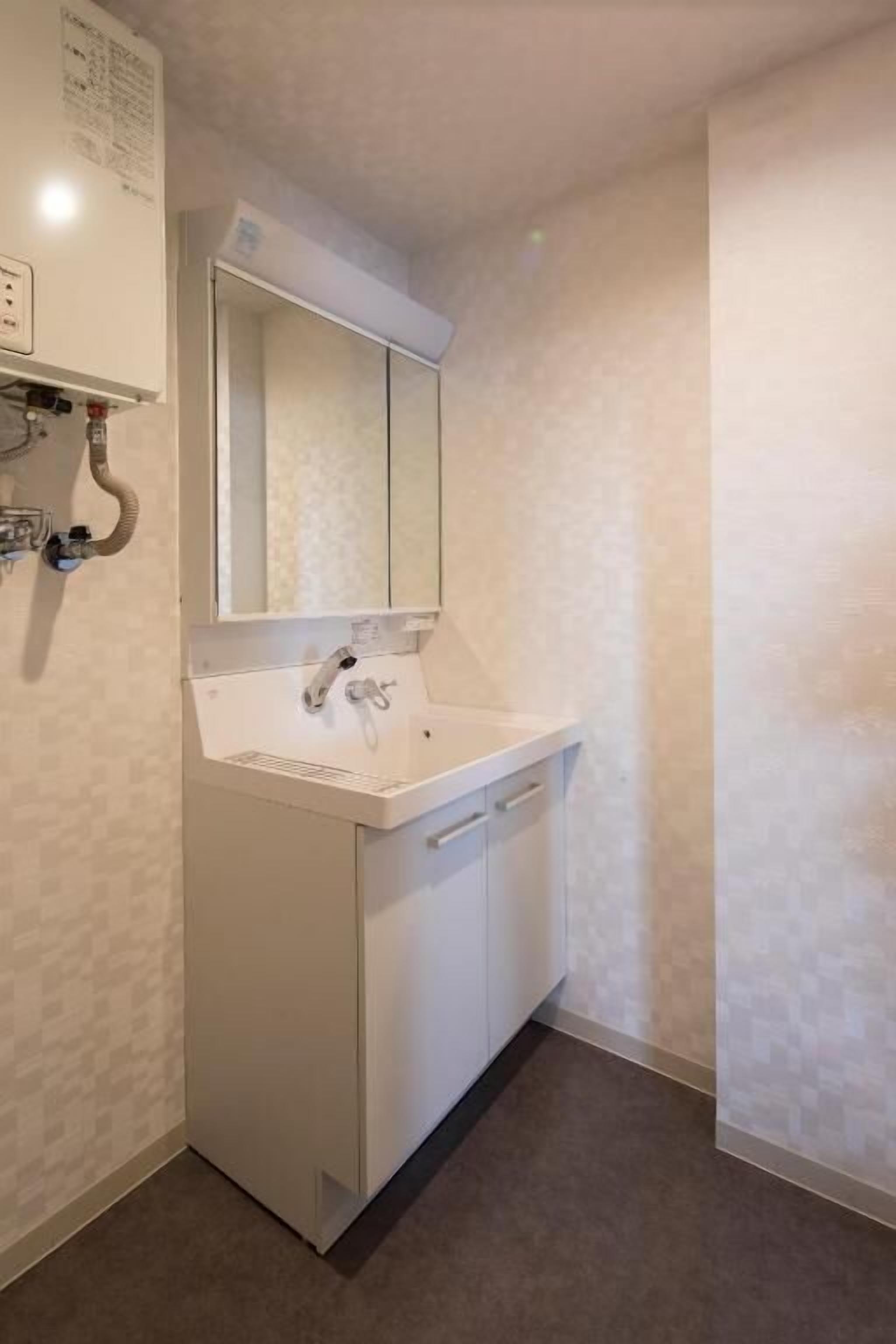 Un baño con lavamanos, espejo y mueble.