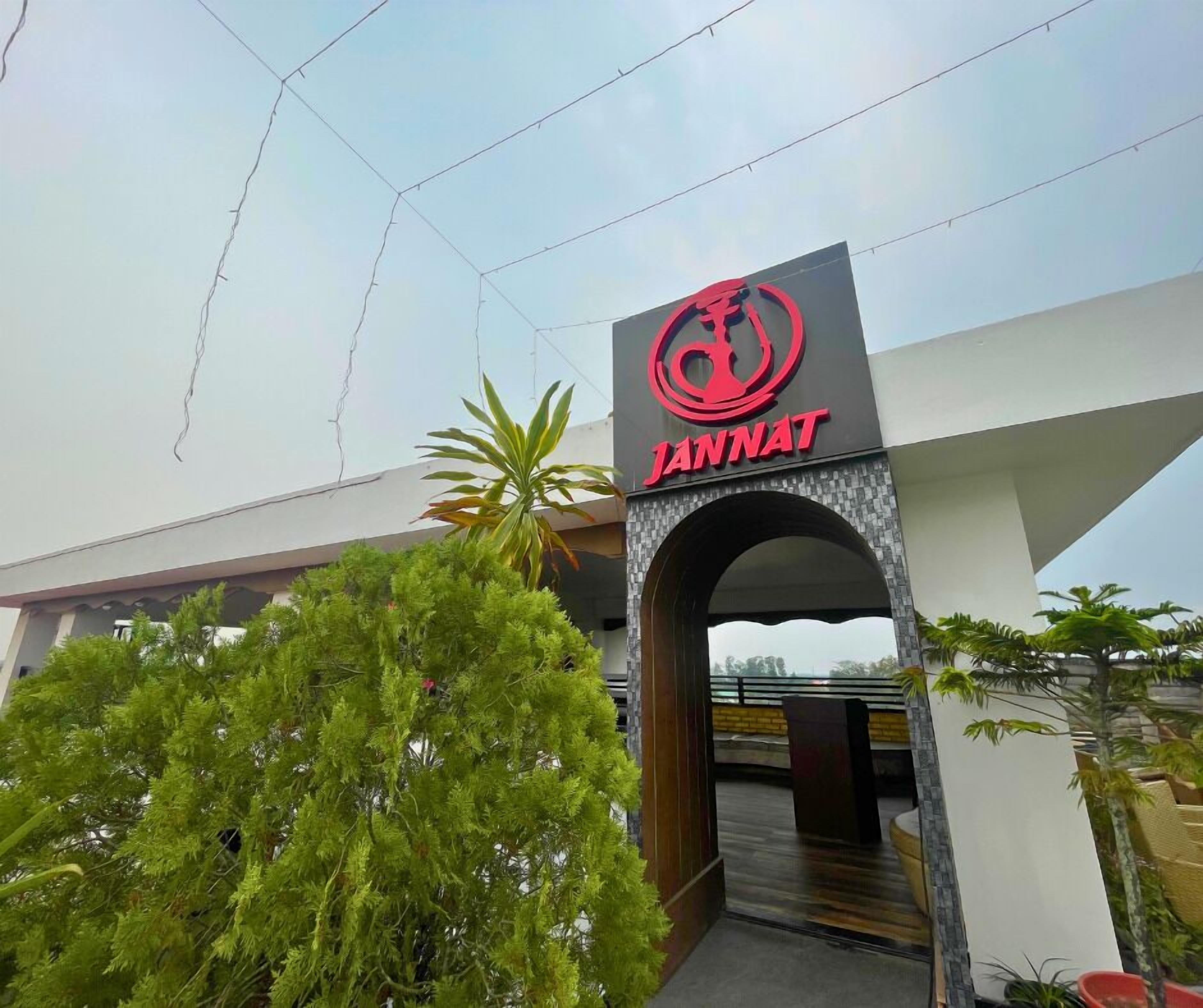 La entrada a un edificio con un llamativo letrero 'JANNAT' sobre un arco.