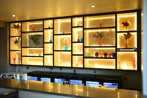 Eine Bar mit Regalen voller Flaschen und Gläsern.