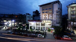 A multi-story building with a ground-level commercial space and upper residential units. - Hotel Nandan (Guwahati)