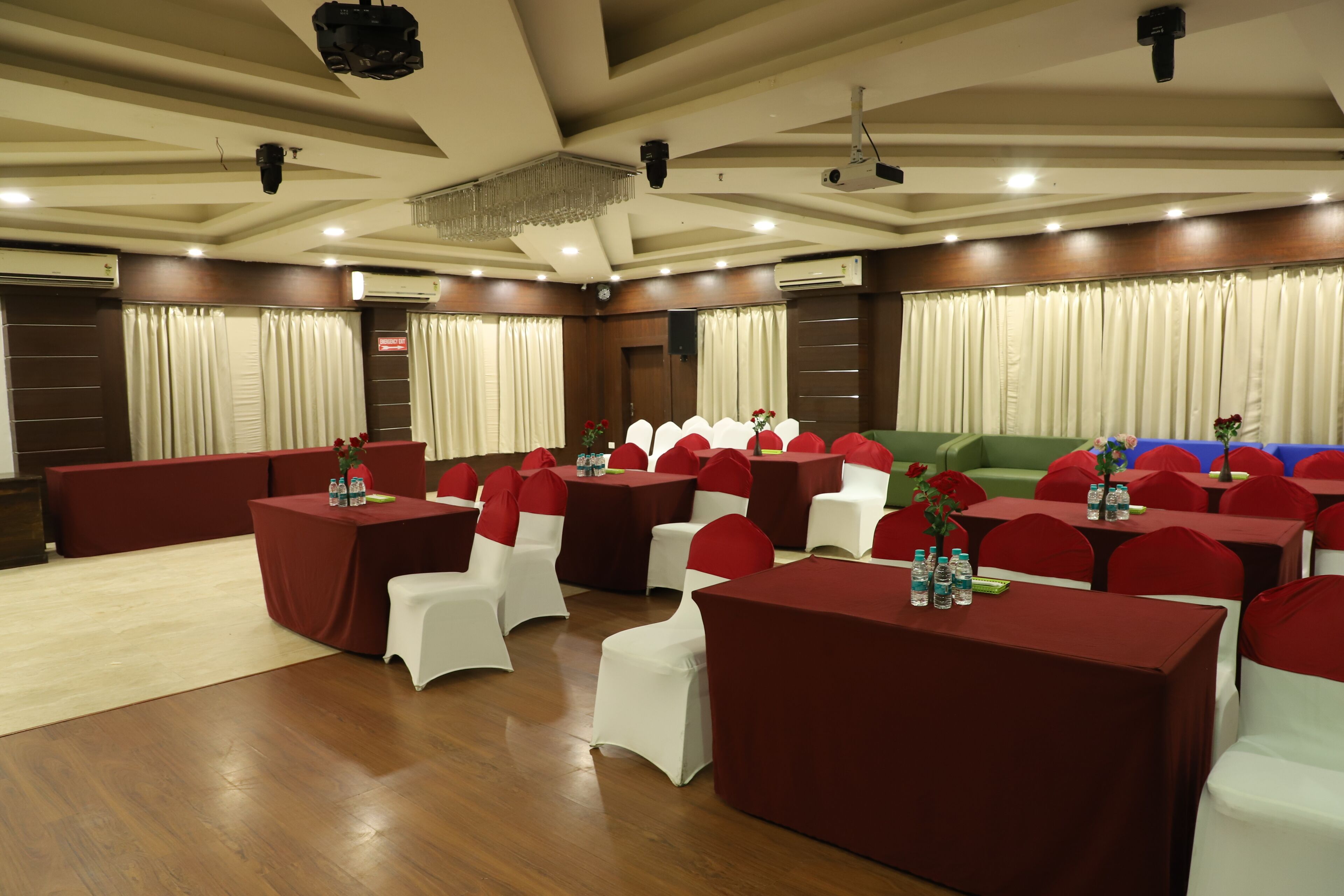 Un salón de conferencias con varias mesas y sillas dispuestas en filas.