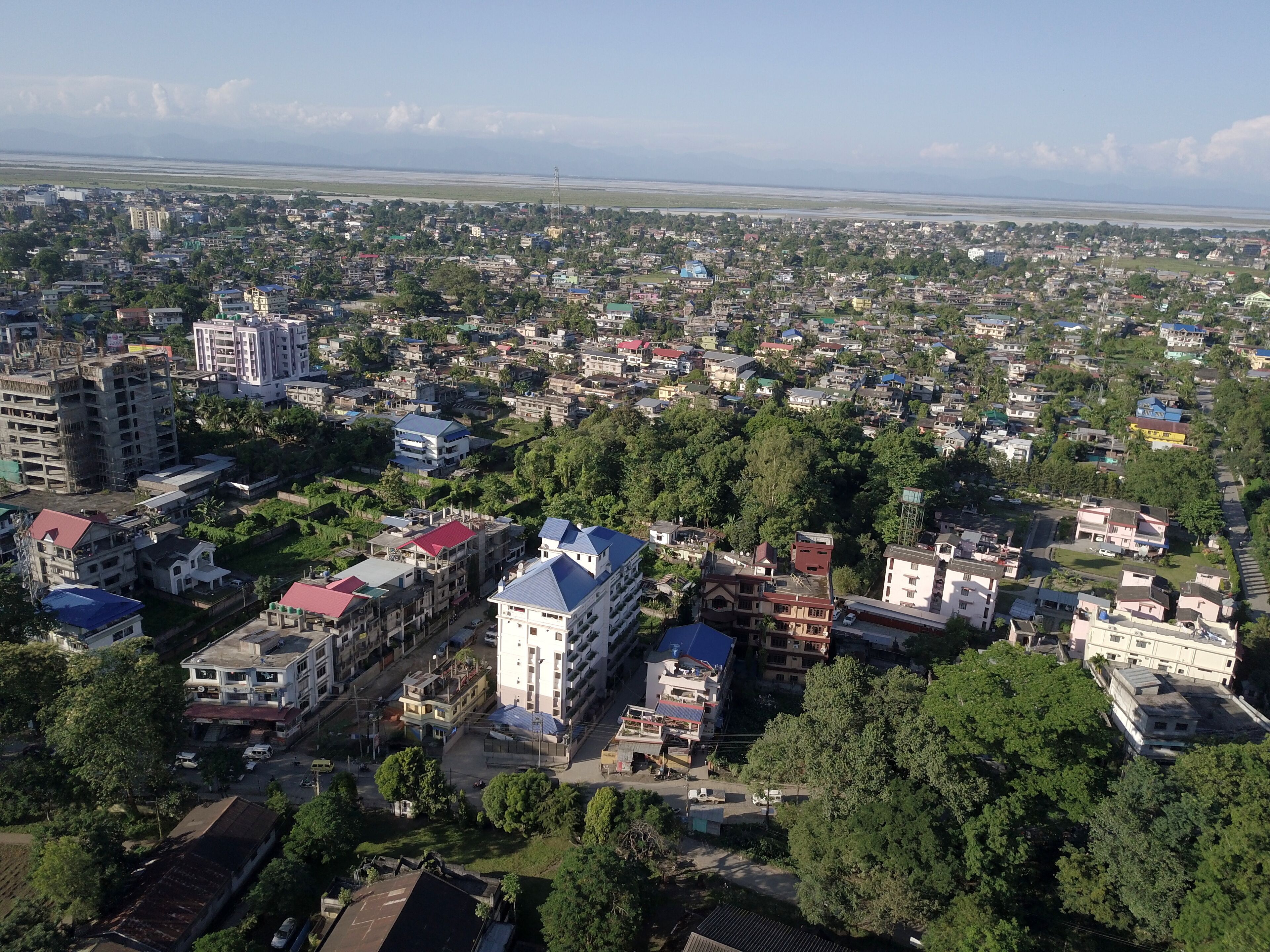 An aerial view of a densely populated urban area with various buildings, including residential and commercial structures.