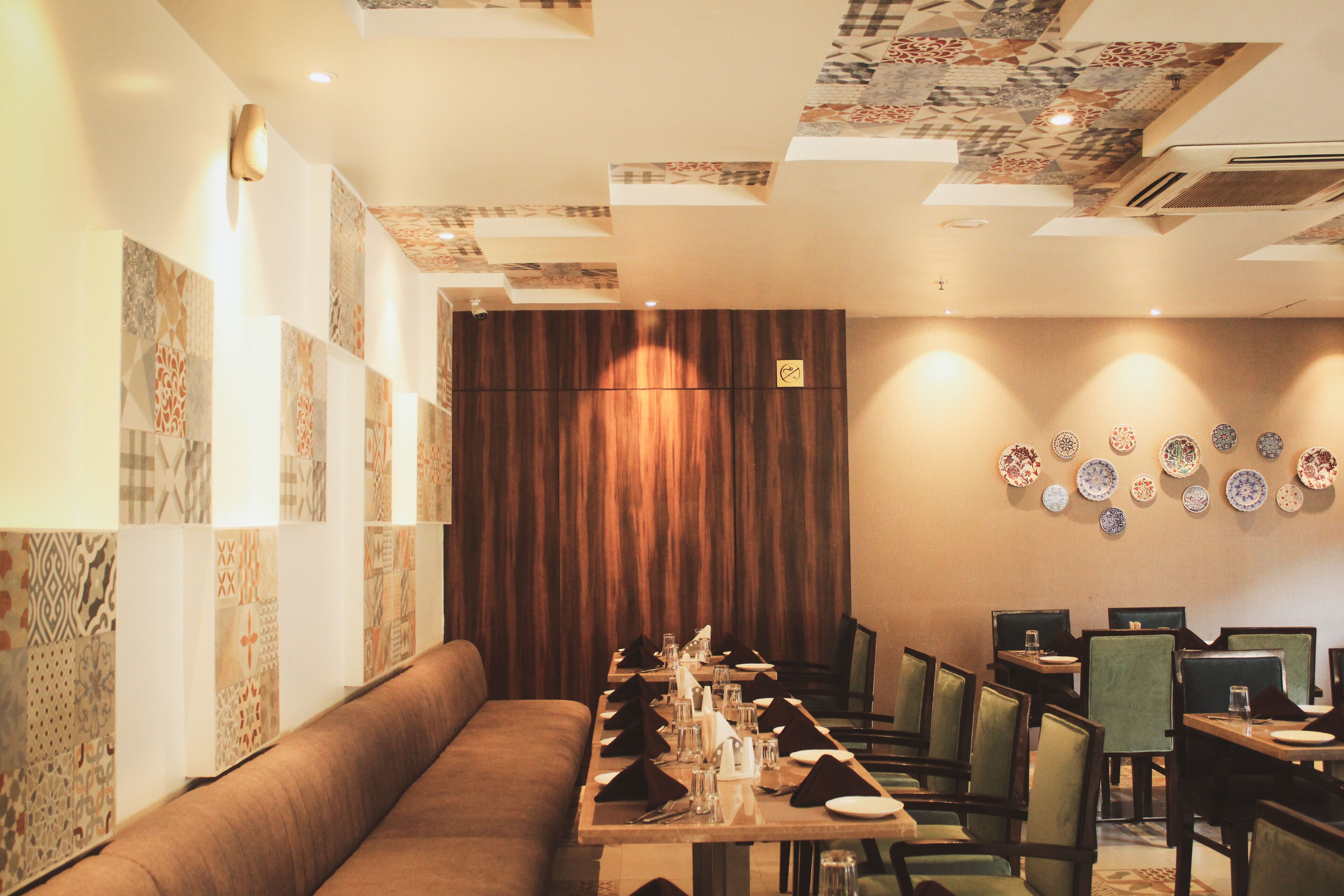 Een restaurant met een lange eettafel gedekt voor een maaltijd, omringd door zitjes en stoelen.