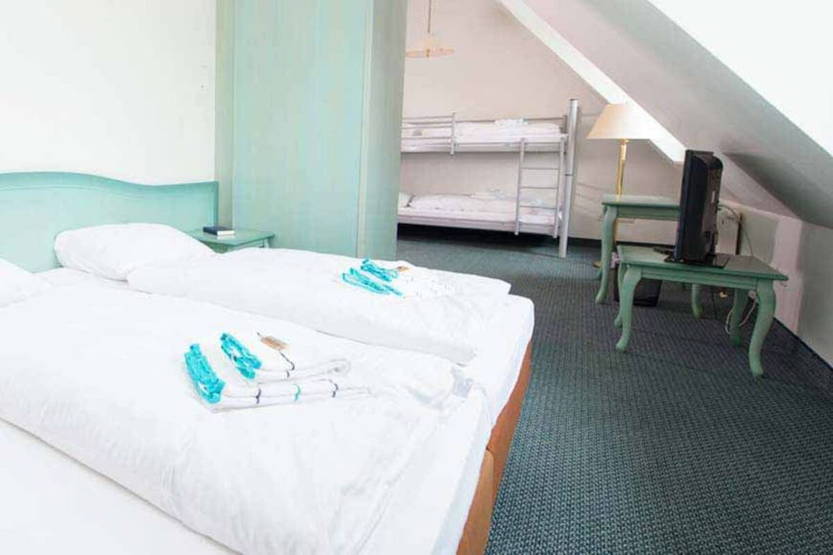 Habitación de hotel con dos camas, un escritorio pequeño y una silla.
