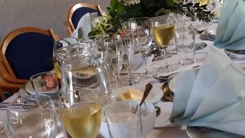 A table set for a meal with empty wine glasses, a plate of food, and a decorative centerpiece.