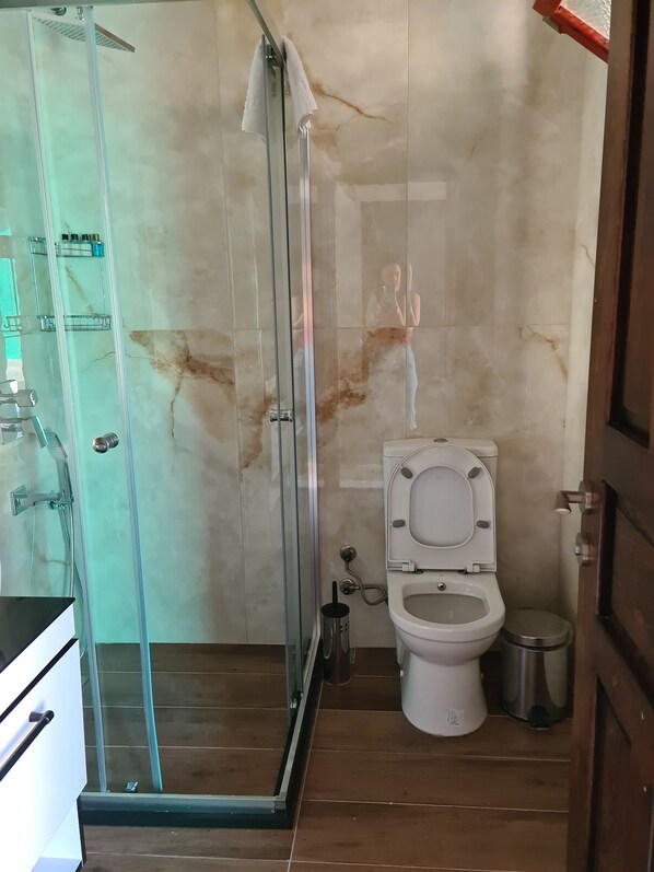 A bathroom with a glass-enclosed shower, a toilet, and a sink. - Akkum Gezer Motel (Marmaris)