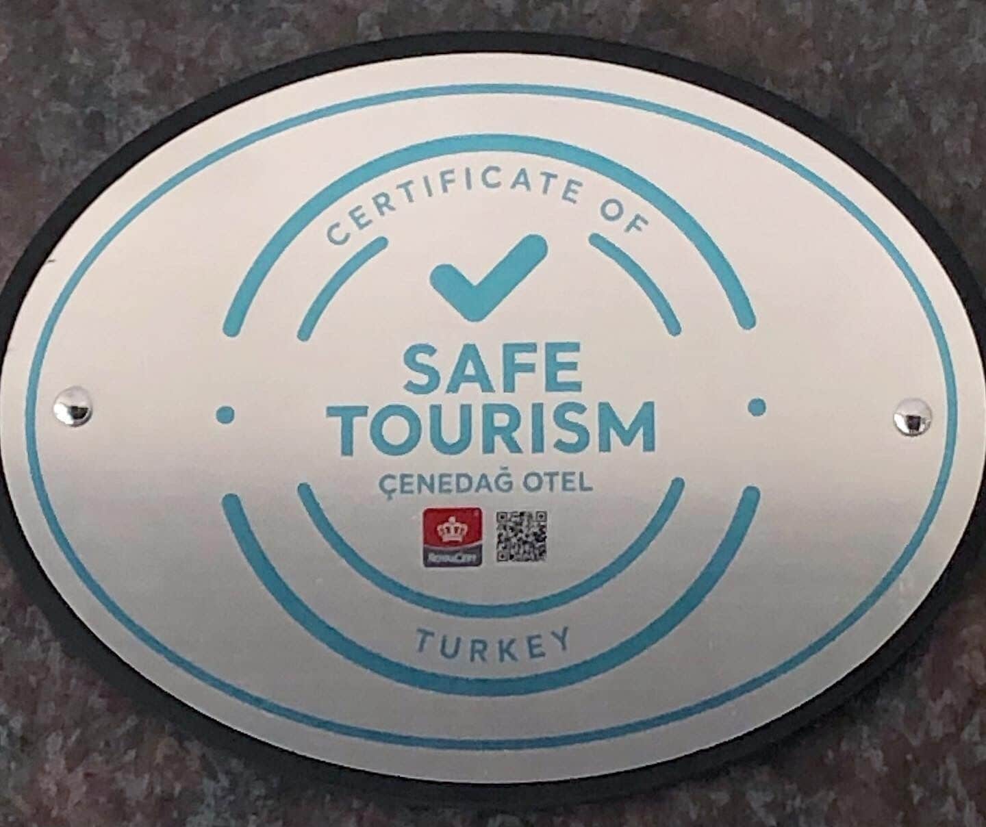 A circular sign with "CERTIFICATE OF SAFE TOURISM" and "TURKEY" text, indicating a safety certification for travel.