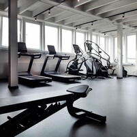 Ein Fitnessraum mit Laufbändern, Ergometer und einer Bank.
