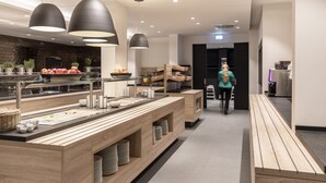 A modern kitchen area with wooden countertops, stainless steel appliances, and pendant lighting. - sylc. Apartmenthotel (Hamburg)
