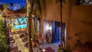A pool area with lounge chairs and a decorative fountain, surrounded by potted plants and a tiled floor. - Majorelle City Center Boutique Hôtel (Marrakech)