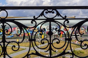 A view through ornate metalwork, featuring a large, colorful mural and a modern building structure. - Hotel Arok (Strasbourg)