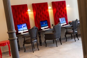 A modern office with three desks, each with a computer monitor, black leather chairs, and red upholstered headboards. - Hotel Arok (Strasbourg)