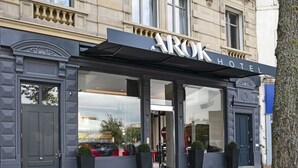 A hotel entrance with a large glass facade, a black awning, and a sign reading "AROK HOTEL". - Hotel Arok (Strasbourg)
