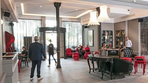 A hotel lobby with a reception desk, seating areas, and a bar. - Hotel Arok (Strasbourg)