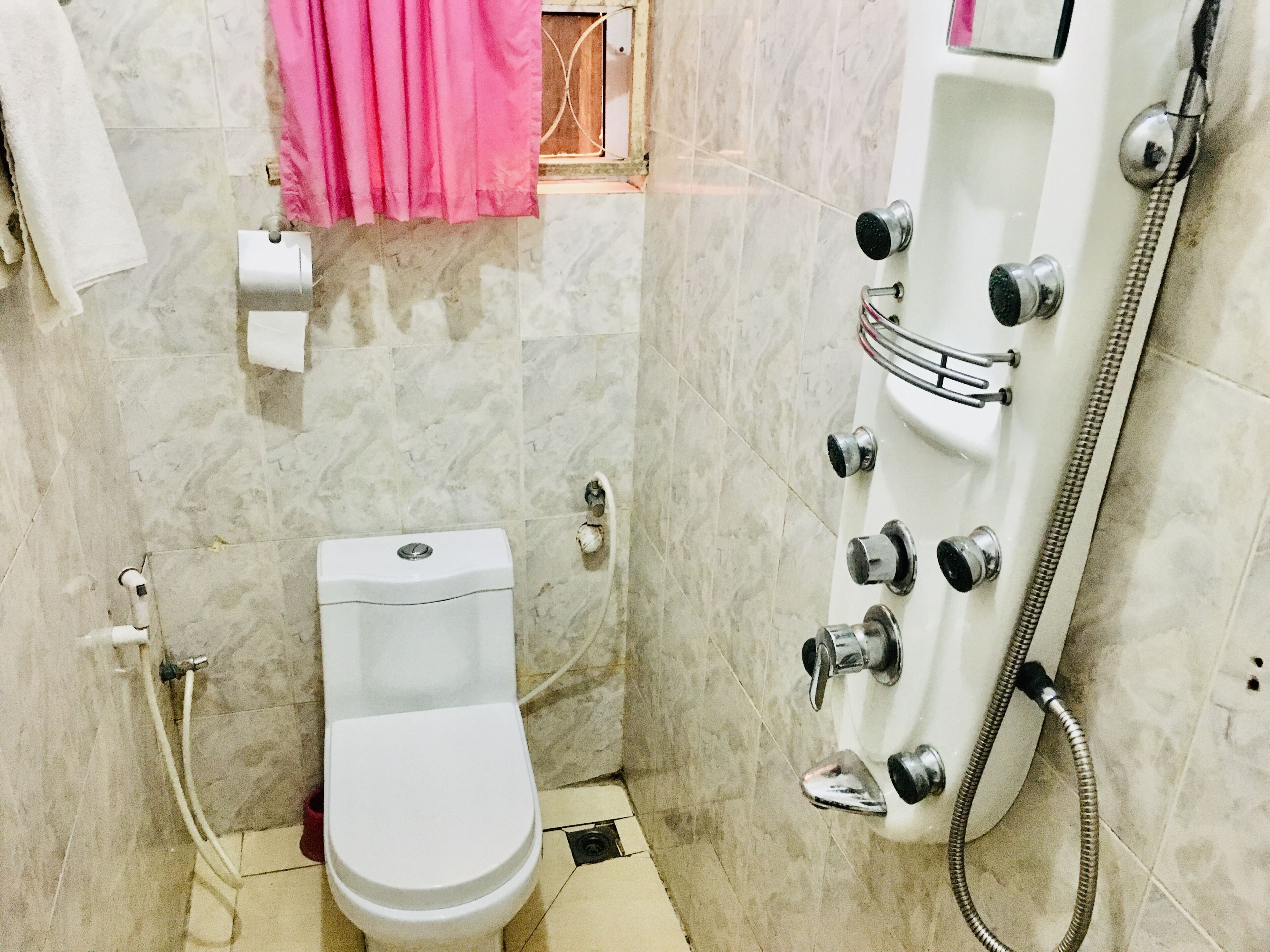 A small bathroom with a toilet, a shower, and a sink.