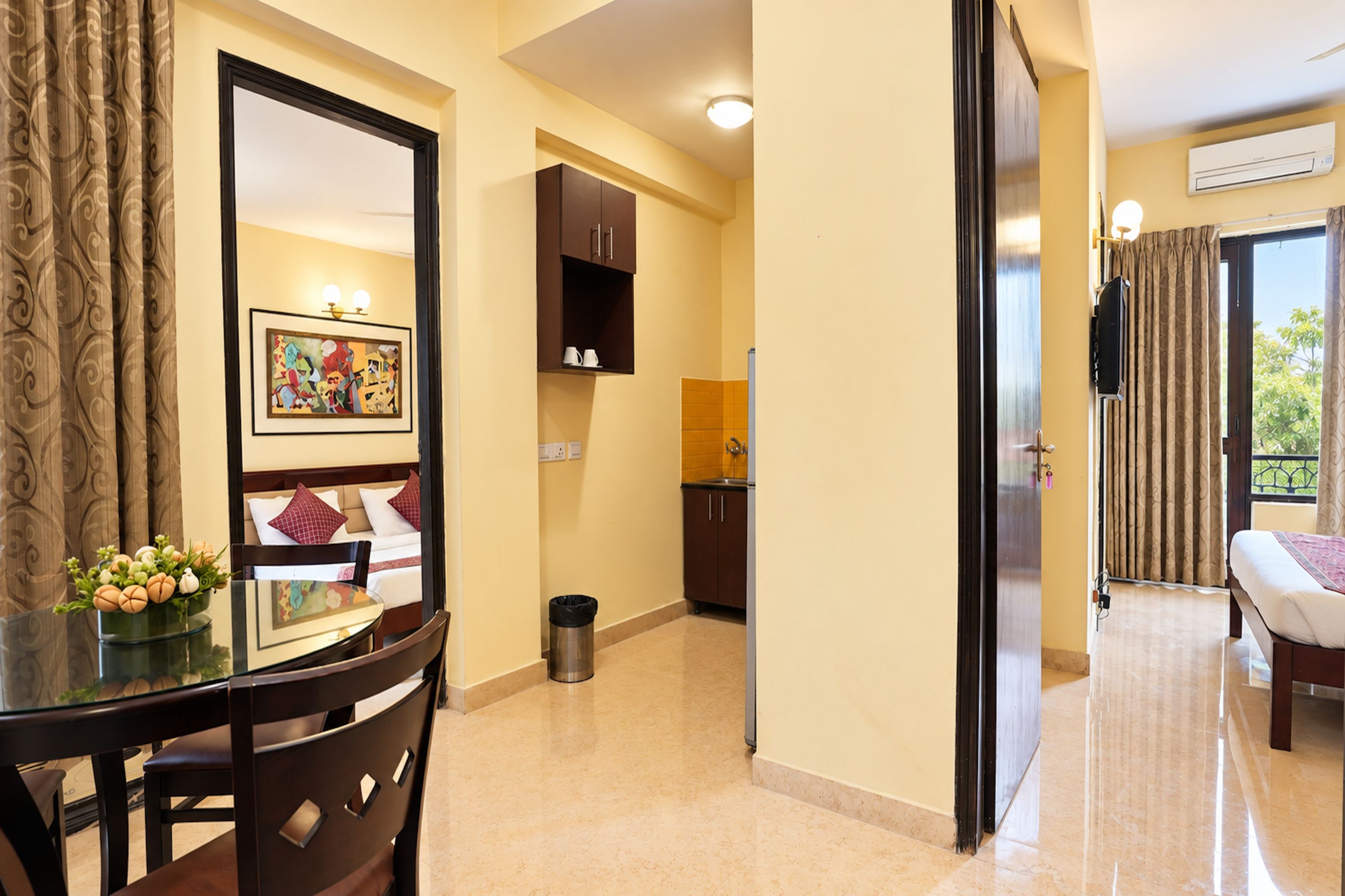 A hotel room with a dining area, a bed, and a view of the outdoors.
