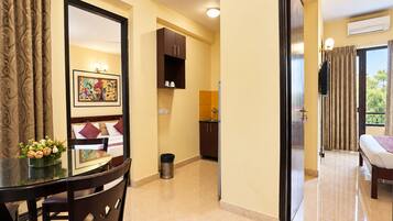 A hotel room with a dining area, a bed, and a view of the outdoors.
