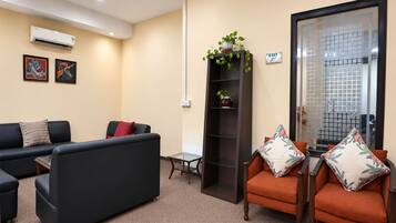 A modern waiting area with a sofa, chairs, a small table, and a decorative plant.