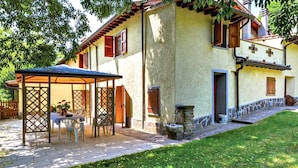 Une maison traditionnelle dotée d’un patio couvert, d’un escalier en pierre et d’une pelouse bien entretenue.