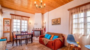 Ein gemütliches Wohnzimmer mit Kamin, Holzmöbeln und einem Essbereich.