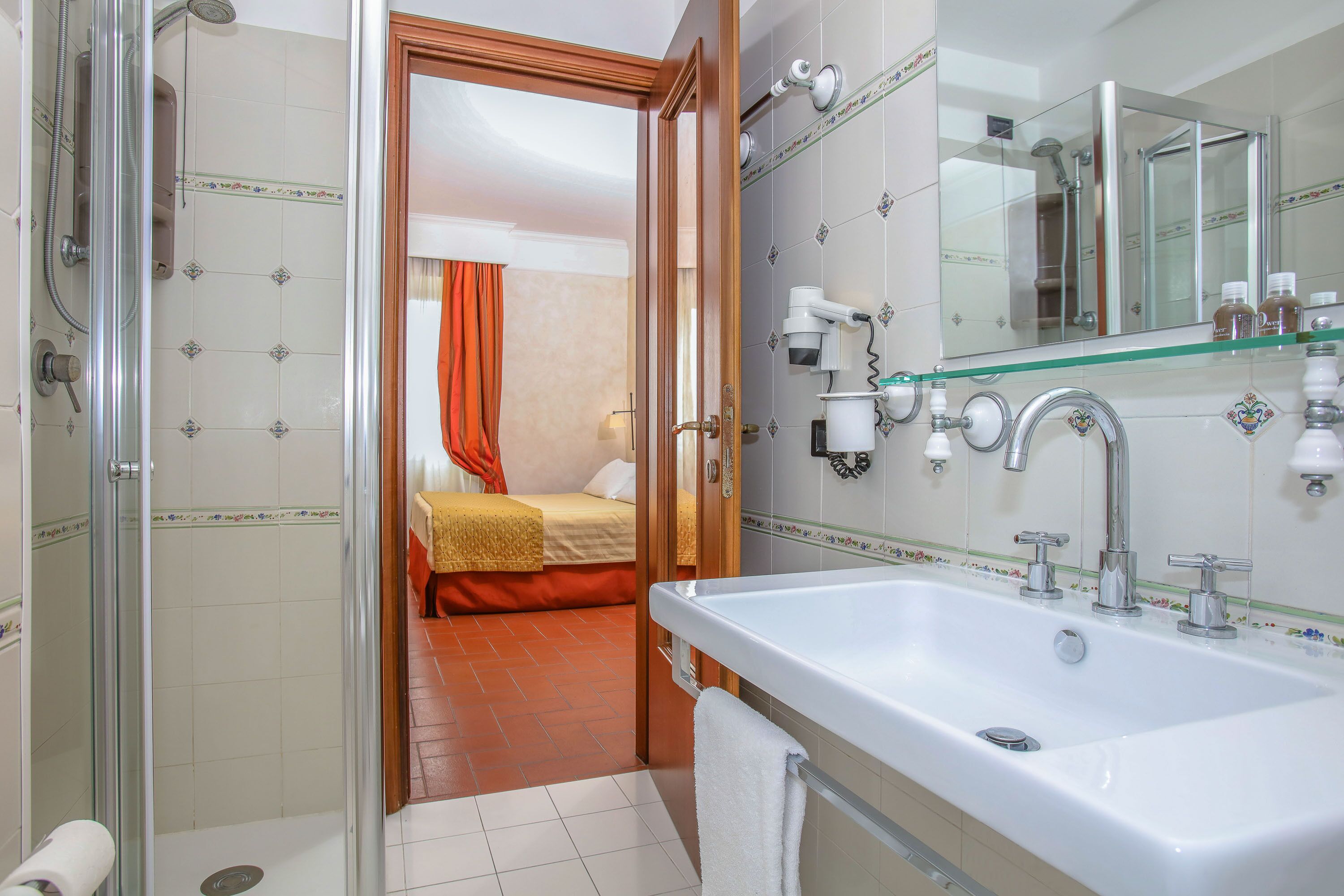 Une salle de bain avec une douche, un lavabo et un miroir.