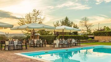 Una piscina al aire libre de temporada, sombrillas