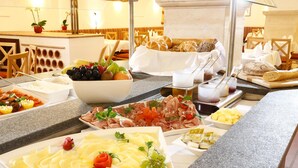 Buffet amb diferents plats, incloent formatge, fruita i carn.