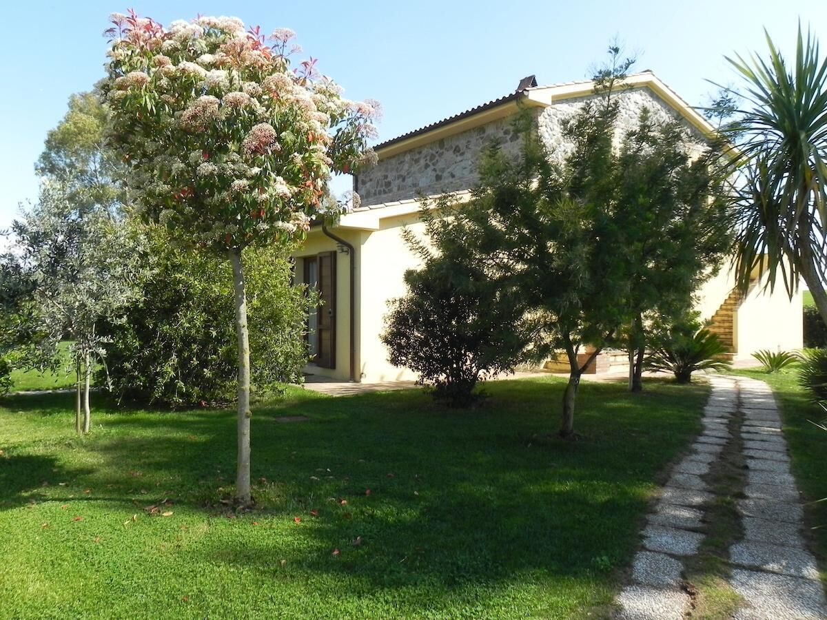 Une maison avec une façade en pierre, un chemin pavé et une pelouse bien entretenue.