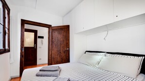 A bedroom with a bed, a wooden door, and a white wall. - Bragora Smoochy Attic Venice (Venice)