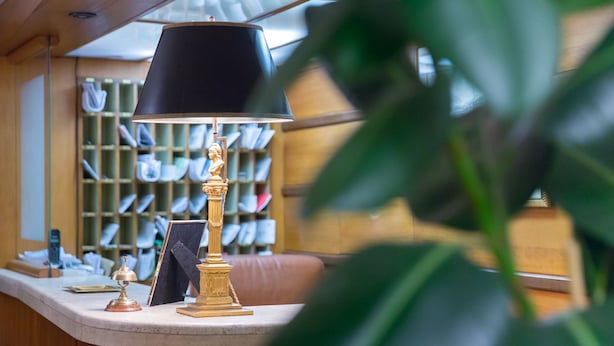 Un comptoir d’accueil avec une lampe, un tableau encadré et une bibliothèque remplie de livres.