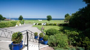 A parking area with a view of the sea, surrounded by greenery and a few potted plants. - Sunny Brae (Nairn)