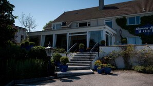 A two-story building with a tiled roof, a front entrance with steps, and a sign that reads "Bunny Hotel". - Sunny Brae (Nairn)