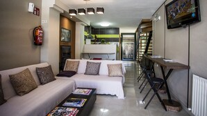 A modern living room with a sofa, coffee table, and a TV mounted on the wall. - Pension Siete en el Camino (Sarria)