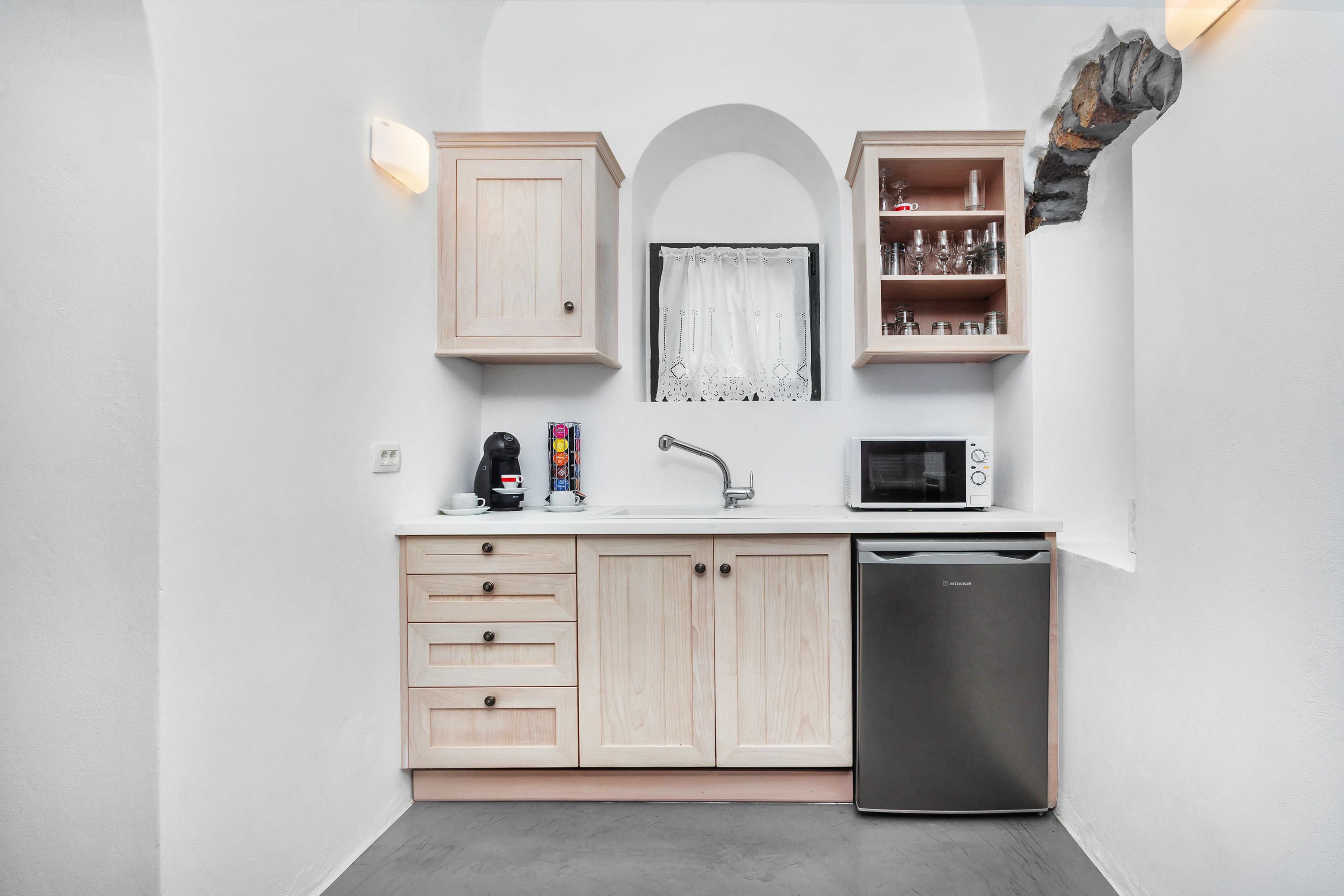 A modern kitchen with wooden cabinets, a microwave, a dishwasher, and a coffee maker.