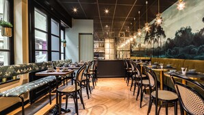 Un restaurante con una barra larga, cabinas y un mural de un paisaje forestal.