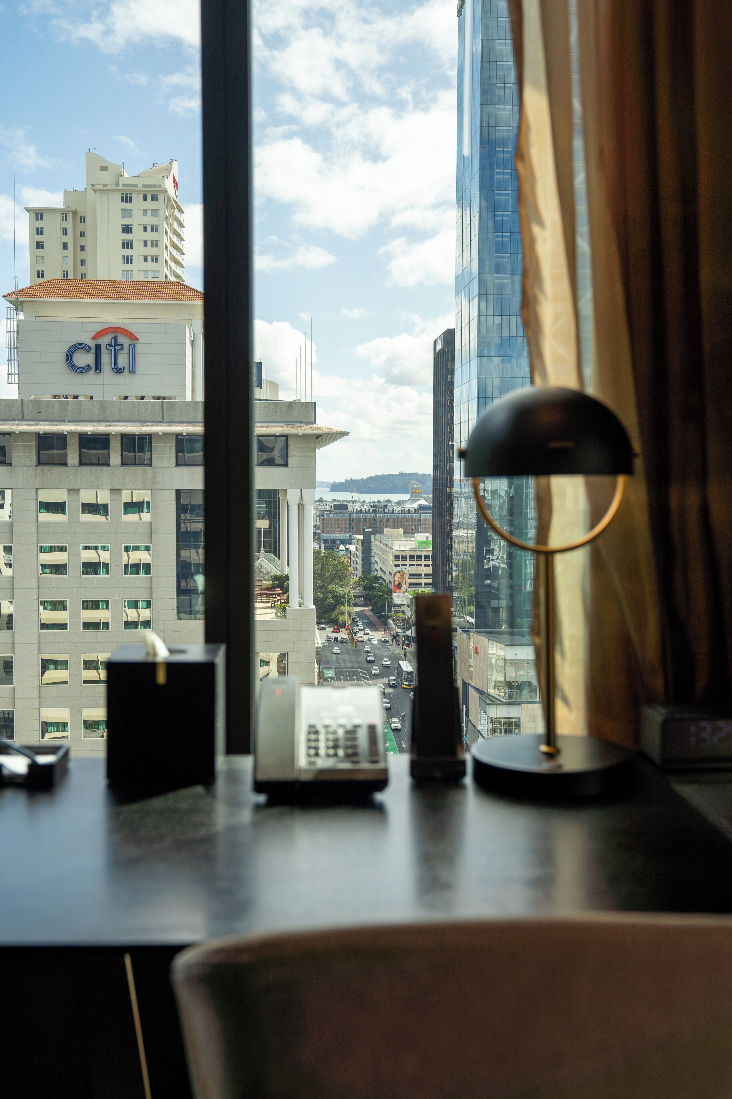 A view from a hotel room window overlooking a cityscape with a Citi building and modern skyscrapers.