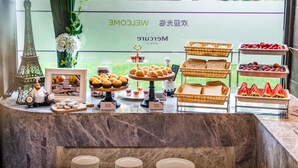 Ein Buffet mit verschiedenen Speisen und einem dekorativen Modell des Eiffelturms.